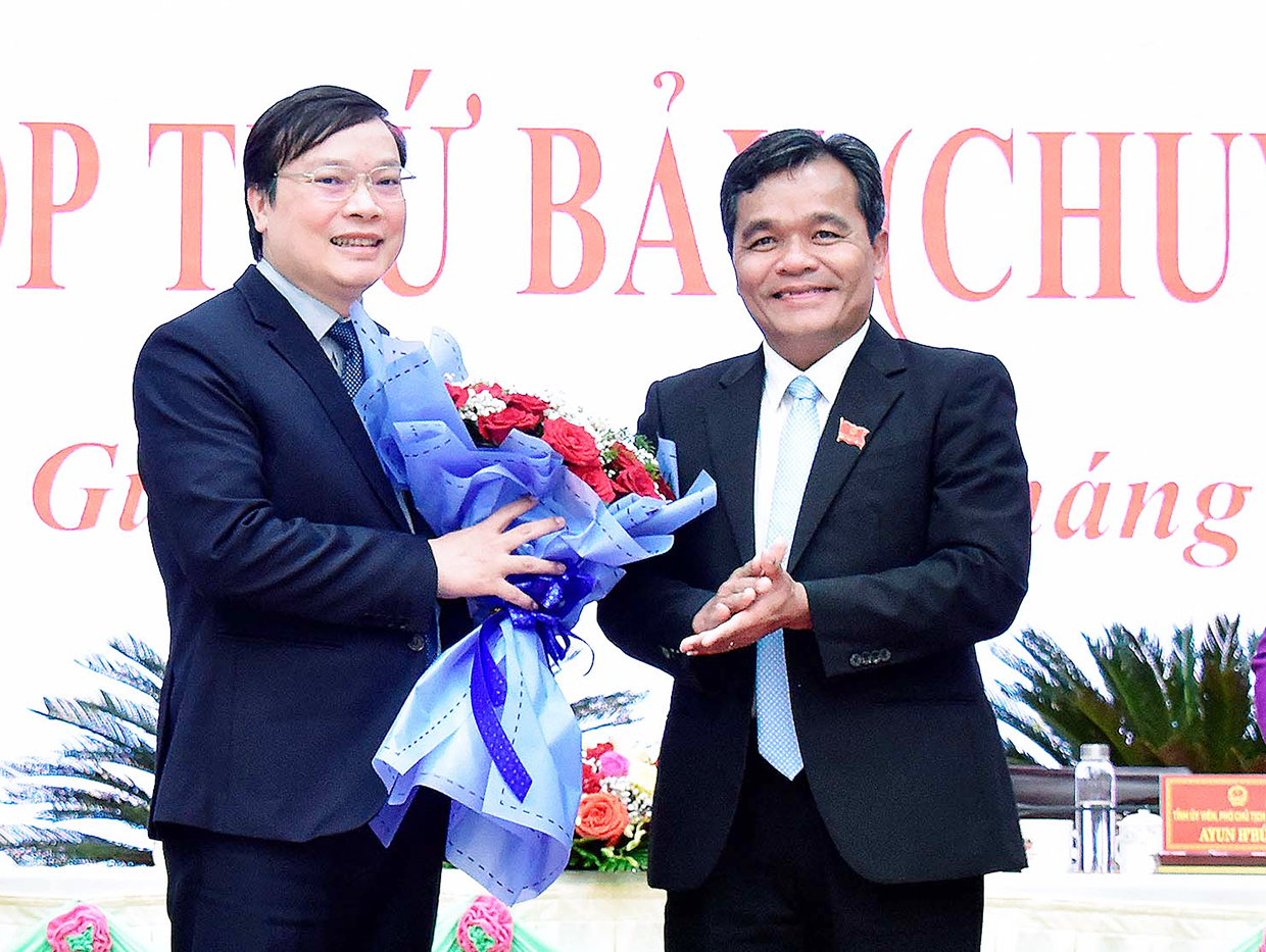 Chủ tịch HĐND tỉnh Hồ Văn Niên (bìa phải) tặng hoa chúc mừng tân Chủ tịch UBND tỉnh Trương Hải Long. Ảnh: Báo Gia Lai