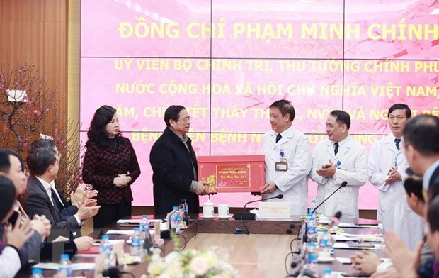 Thủ tướng Phạm Minh Chính tặng quà cho đại diện Bệnh viện Bệnh nhiệt đới Trung ương. (Ảnh: Dương Giang/TTXVN).