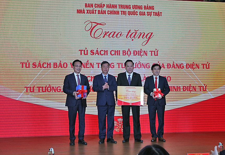 Đồng chí Vũ Trọng Lâm, Giám đốc - Tổng Biên tập Nhà xuất bản Chính trị quốc gia Sự thật (thứ 2 từ trái sang) trao tài liệu công tác đảng và 