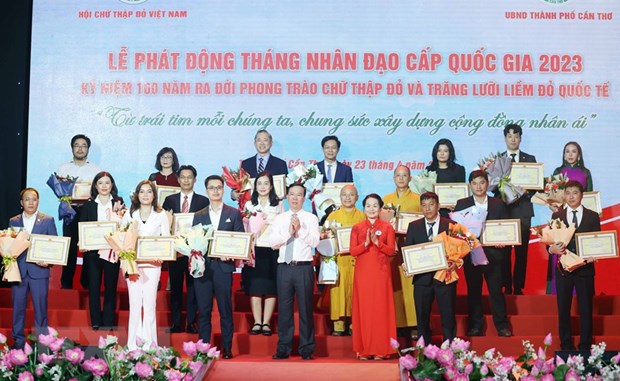 Chủ tịch nước Võ Văn Thưởng, Chủ tịch danh dự Hội Chữ thập Đỏ Việt Nam và bà Bùi Thị Hòa, Chủ tịch Hội Chữ thập Đỏ Việt Nam tặng hoa và trao bảng Ghi nhận tấm lòng vàng nhân đạo. (Ảnh: Thống Nhất/TTXVN).