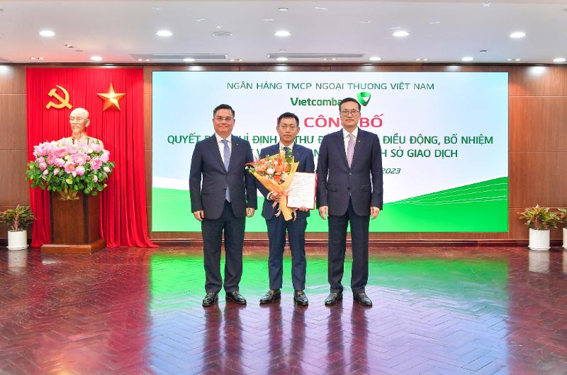 Đ/c Phạm Quang Dũng – Bí thư Đảng ủy, Chủ tịch Hội đồng Quản trị Vietcombank (bên phải) và Tổng Giám đốc Vietcombank Nguyễn Thanh Tùng (bên trái) trao Quyết định và tặng hoa chúc mừng ông Đặng Kiên Định – tân Giám đốc Vietcombank chi nhánh Sở Giao dịch.