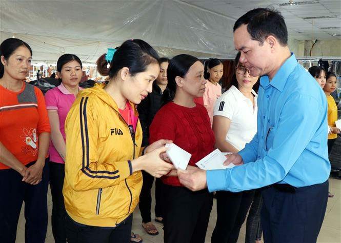 Chủ tịch Tổng Liên đoàn Lao động Việt Nam Nguyễn Đình Khang trao tặng tiền hỗ trợ công nhân, đoàn viên công đoàn Công ty May Hà Tĩnh. (Ảnh: TTXVN)