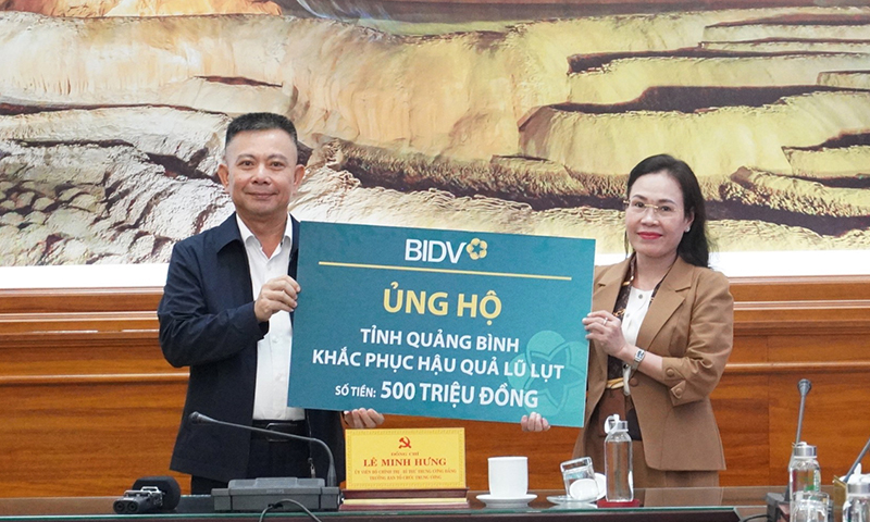 Đại diện Ngân hàng thương mại cổ phần Đầu tư và Phát triển Việt Nam trao 500 triệu đồng cho tỉnh Quảng Bình để hỗ trợ người dân vùng lũ.