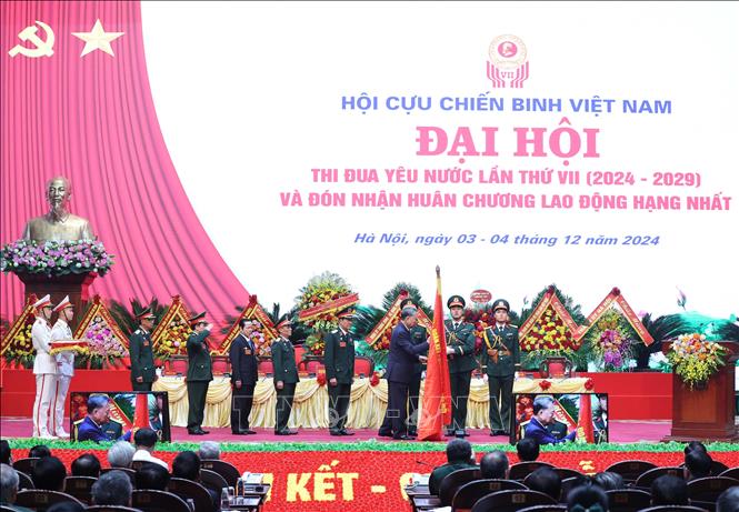 Tổng Bí thư Tô Lâm gắn Huân chương Lao động hạng Nhất lên lá cờ truyền thống Hội Cựu chiến binh Việt Nam.