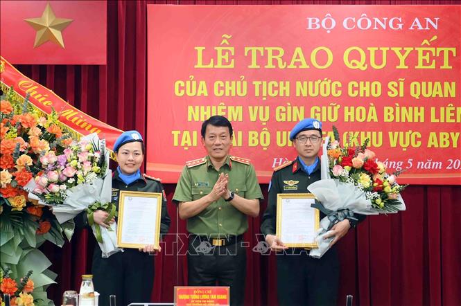 Thượng tướng Lương Tam Quang, Thứ trưởng Bộ Công an trao Quyết định của Chủ tịch nước cho 2 sĩ quan CAND đi thực hiện nhiệm vụ gìn giữ hoà bình Liên hiệp quốc. Ảnh: TTXVN