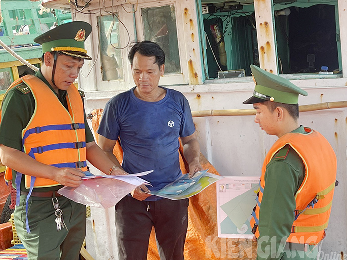 Chiến sĩ Đồn Biên phòng cửa khẩu cảng Hòn Chông, huyện Kiên Lương (Kiên Giang) tuyên truyền, phát thư kêu gọi của Tỉnh ủy, UBND tỉnh về chống khai thác IUU đến ngư dân. Ảnh: Báo Kiên Giang