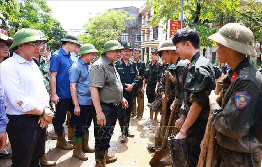 Thủ tướng Phạm Minh Chính động viên các lực lượng tham gia khắc phục hậu quả mưa lũ tại thành phố Yên Bái. Ảnh: Dương Giang/TTXVN.