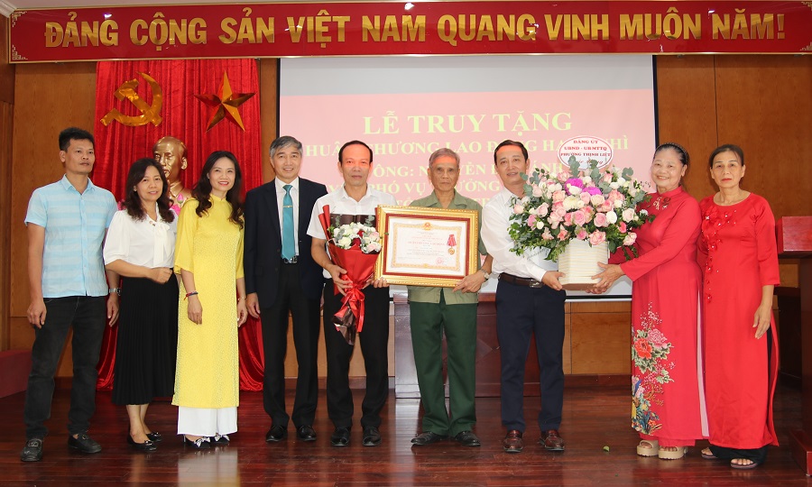 Đồng chí Nguyễn Kiến Thuận, Bí thư Đảng ủy phường Thịnh Liệt lên tặng hoa cho gia đình ông Nguyễn Đức Ánh.